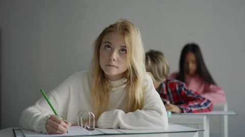 Smart girl making notes during lesson Stock Footage 142493759