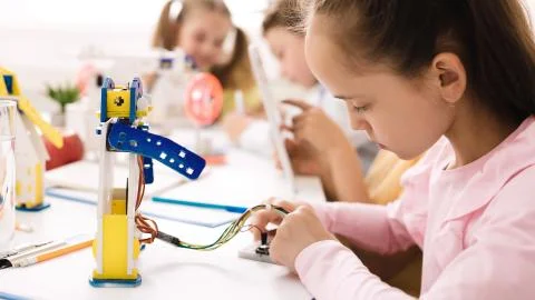 Smart girl programming robot, working with wires and circuits Foto stock