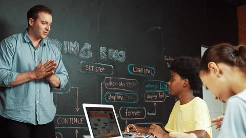 Smart girl programming system while african student fixing robot. Edification. Foto stock