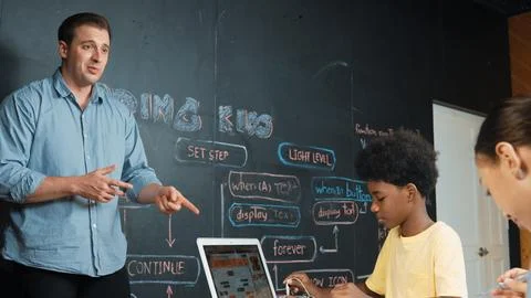 Smart girl programming system while african student fixing robot. Edification. Foto stock