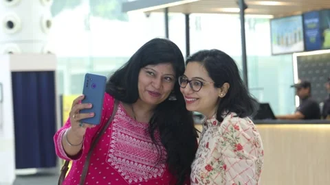Smart girls using mobile phone standing in shopping mall. Stock Footage 245296357