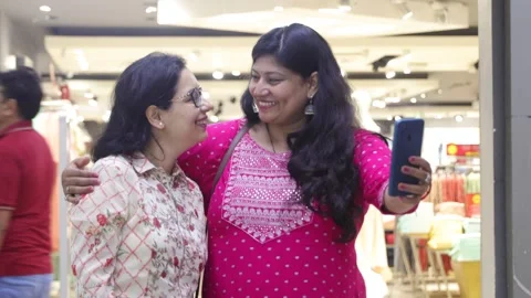 Smart girls using mobile phone standing in shopping mall. Stock Footage 245296406