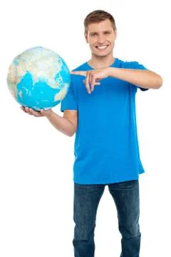Smart guy pointing at the globe. Dressed in casuals Stock Photos
