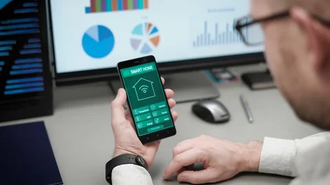 Smart home, application on the phone. A man manages various parameters of his Stock Footage 82351482