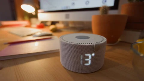 Smart Home Assistant Displaying Time and Temperature on Desk Stock Footage 340789991