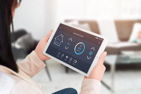 Smart home control app on tablet display in woman hands. Home, living room in Fotos Stock