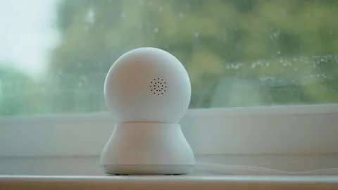 Smart home security camera rotating for surveillance monitoring near window. IP 库存影片 335143959