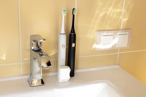 Smart interactive electric sonic toothbrushes on the bathroom sink, family se Stock Photos