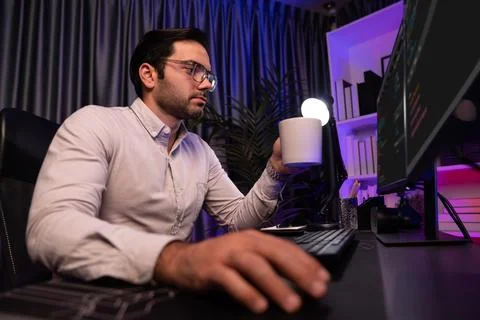Smart IT developer drinking coffee cup while working code on pc screen. Surmise. Stock Photos