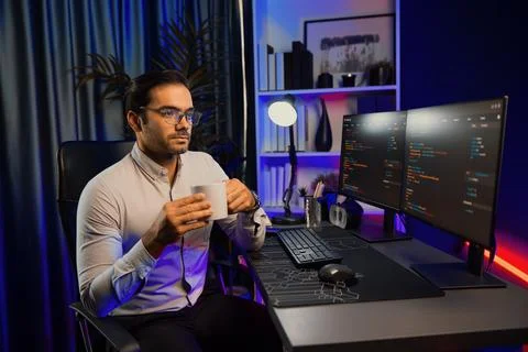 Smart IT developer drinking coffee cup while working code on pc screen. Surmise. Stock Photos
