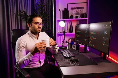 Smart IT developer drinking coffee cup while working code on pc screen. Surmise. Stock Photos