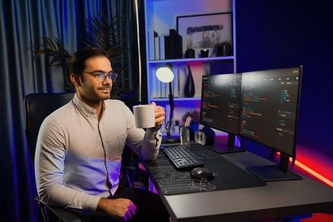 Smart IT developer drinking coffee cup while working code on pc screen. Surmise. Stock Photos