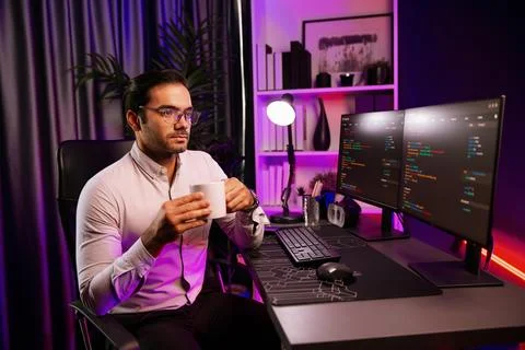 Smart IT developer drinking coffee cup while working code on pc screen. Surmise. Stock Photos
