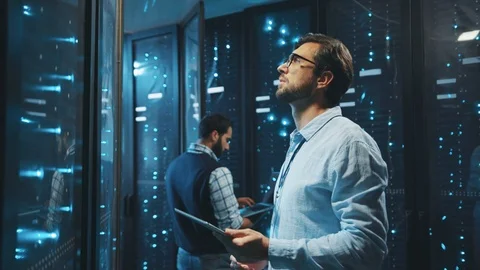 Smart IT engineer working in data center using digital tablet looking into data Stock Footage 119279063