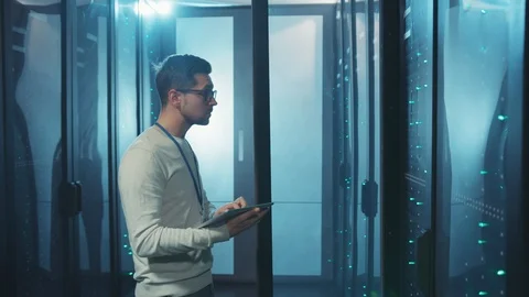 Smart IT technician in data center examining working system of rack server Video stock 119234320