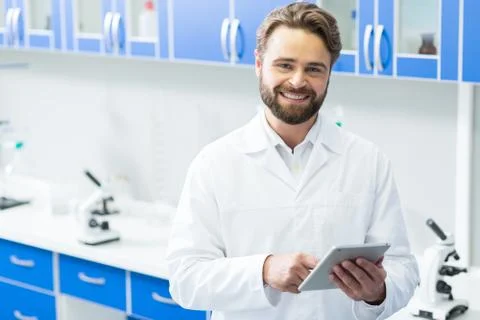 Smart joyful scientist using a tablet Stock Photos
