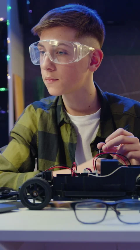 Smart kid assembling and testing electric circuit building and programming car.  Stock Footage 327817733