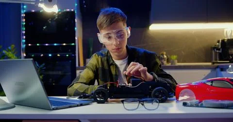 Smart kid assembling and testing electric circuit building and programming car Stock Photos