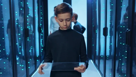Smart kid boy browsing virtual interface on invisible tablet, programming for Stock Footage 121273723