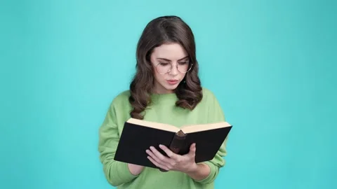 Smart lady academic read textbook isolated cyan color background Video stock 169944253