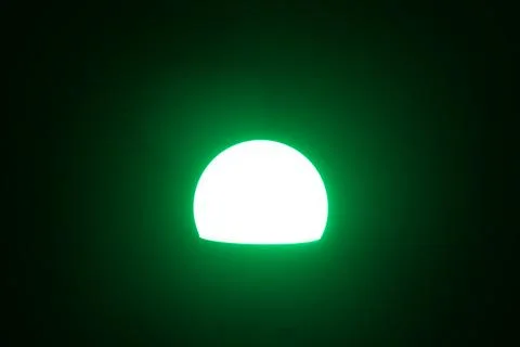 Smart LED Light Bulb Glowing Green in Dark Interior	 Stock Photos