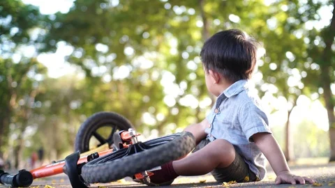 Smart little 1-2 year old boy falling accident balance bike practice in park Stock Footage 126083336