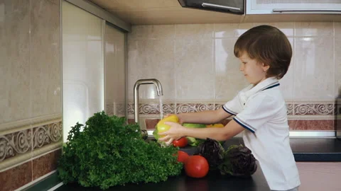 Smart Little Boy Preparing Salad, Washes Bell Pepper, Other Vegetables Video stock 135538704
