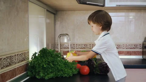 Smart Little Boy Preparing Salad, Washes Bell Pepper, Other Vegetables Video stock 135538859