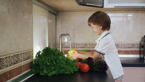 Smart Little Boy Preparing Salad, Washes Bell Pepper, Other Vegetables Video stock 135539276