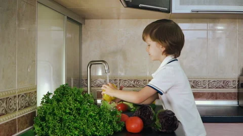 Smart Little Boy Preparing Salad, Washes Bell Pepper, Other Vegetables Video stock 135540184