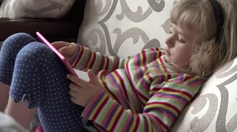 Smart Little Girl Using Tablet Computer while Sitting on Couch. 4k Ultra HD Stock Footage 48143951
