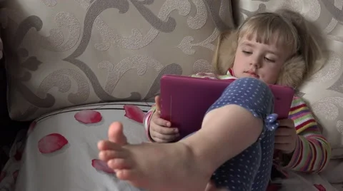 Smart Little Girl Using Tablet Computer while Sitting on Couch. 4k Ultra HD Stock Footage 48144088