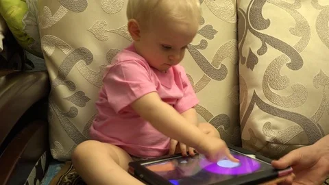 Smart Little Girl Using Tablet Computer while Sitting on Couch. 4k Ultra HD. 4K Stockbeeldmateriaal 82461356