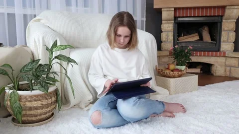 Smart little girl using tablet computer while sitting on couch Stock Footage 154058157