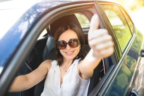 A smart looking middle-aged adult woman wearing sunglasses put her hand out t Stock Photos