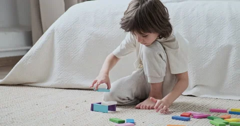Smart male kid constructing multicolored wooden brick blocks development Stock-Footage 162480065