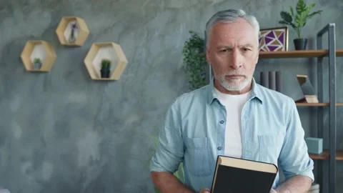 Smart man get book bookcase want study sit divan read diary in apartment Stock Footage 166624499