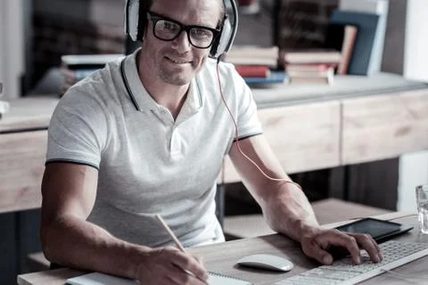 Smart mature guy smiling while working on computer Stock Photos