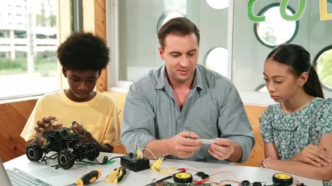 Smart mentor teach about electronic equipment while fix car model. Edification Stock Footage 276229596