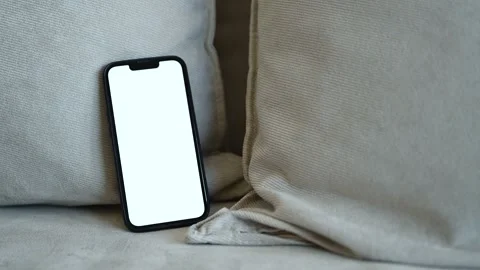 Smart mobile phone device with blank white mockup screen on living room sof.. Stock Footage 321350993