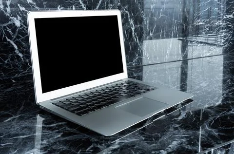 Smart modern laptop with blank screen on marble table. Elegant Design with .. Stockfoto's