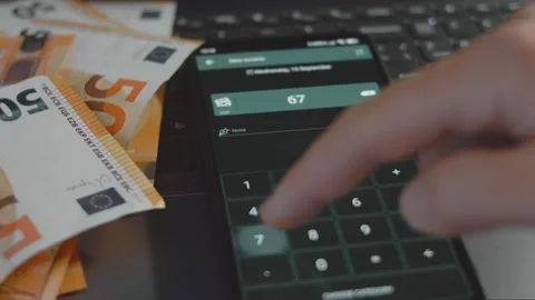 Smart money management. Using technology to track budget. A person who uses a Stock Footage 250388101