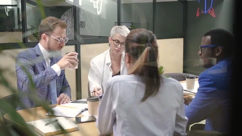 Smart multiethnic group talks about startup project at desk in lighting room. Video stock 98280216