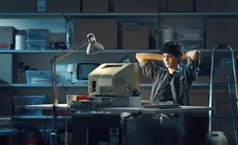 Smart nerd guy using a computer in the garage 스톡 사진