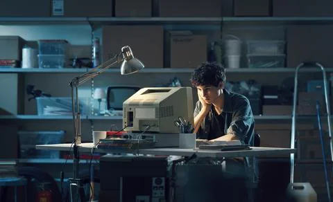 Smart nerd guy using a computer in the garage Stock Photos