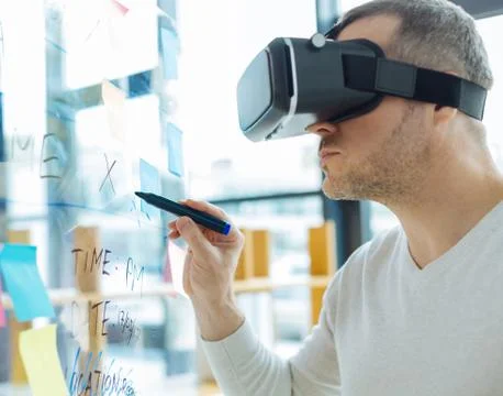 Smart nice man looking at the transparent board Stock Photos