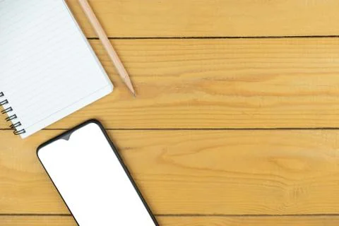 Smart phone and empty notepad and pencil on desk, mock up on screen, copy spa Stock Photos