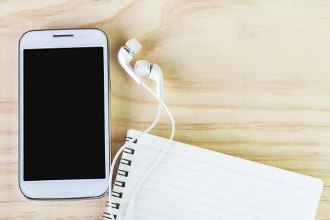 Smart phone and open notebook on wooden table Stock Photos