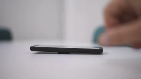 Smart phone and Technology Concept: Young man tourning his phone on the table Stock Footage 125524301