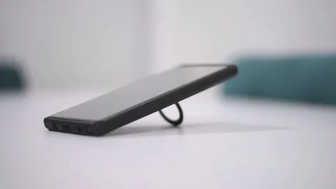 Smart phone and Technology Concept: Young man tourning his phone on the table Stock Footage 125524419
